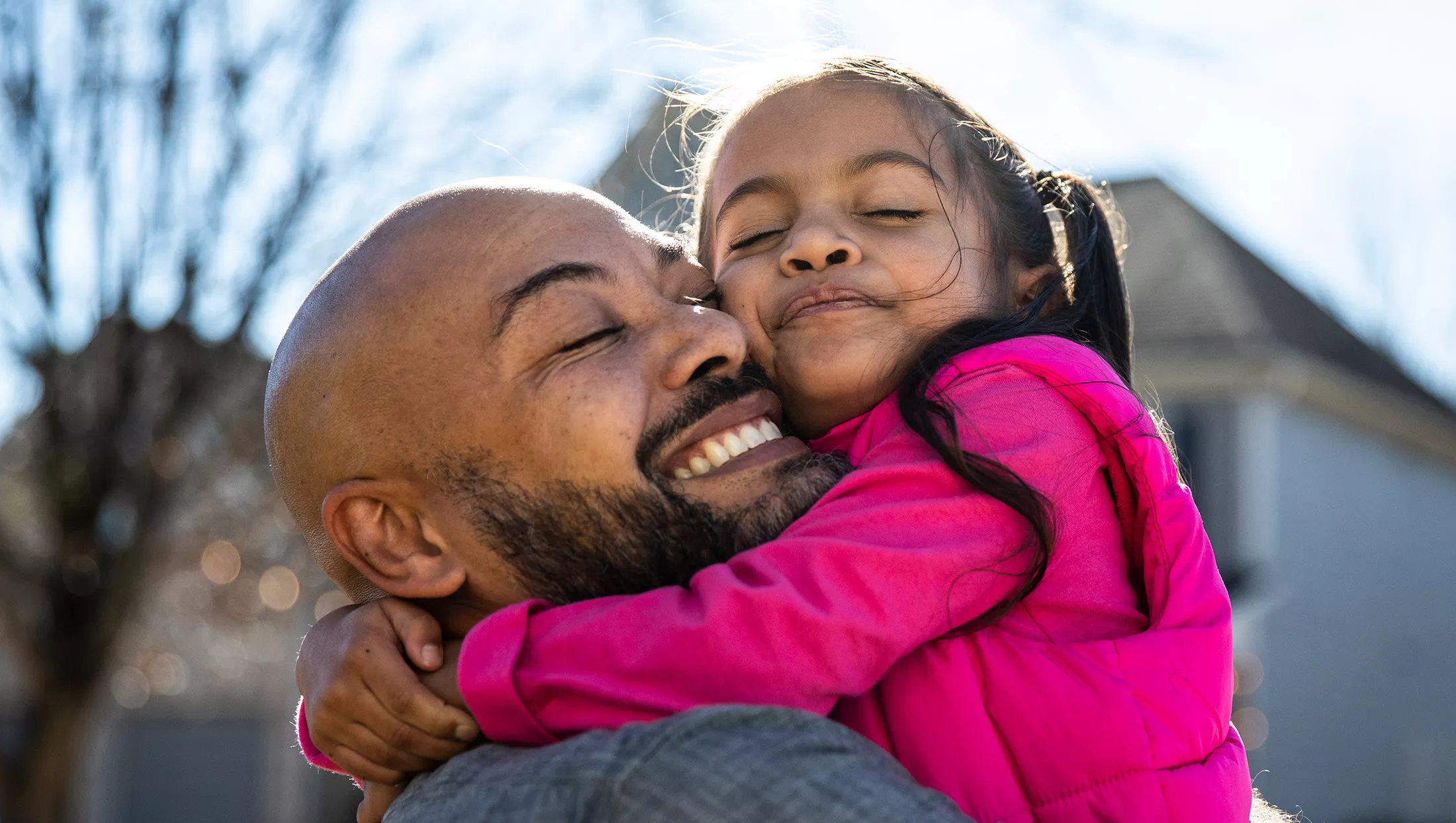 Father holding young daughter outdoors 