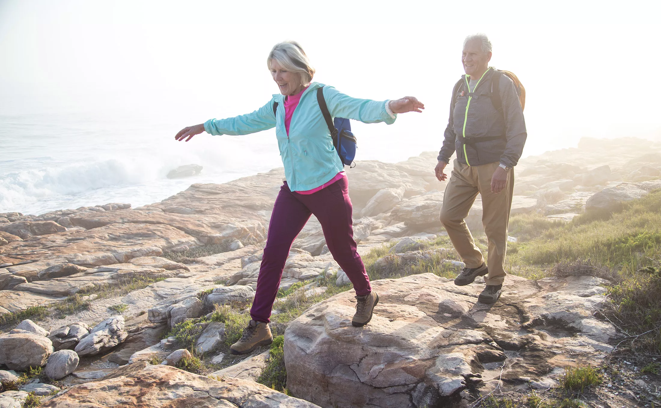 Senior couple hiking outdoors together on a coastal path near the sea