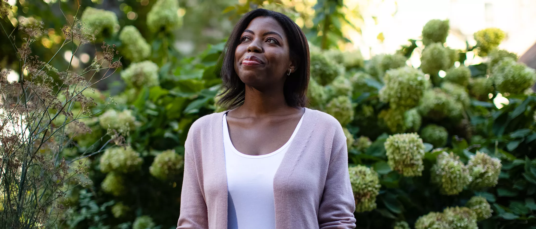 A woman in a garden, smiling