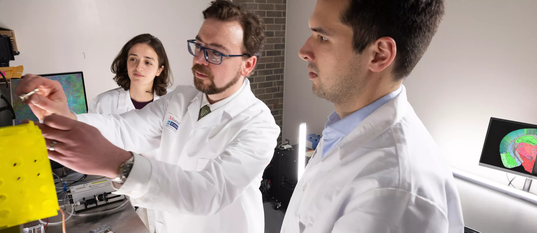 A group of researchers looking at a piece of equipment in a lab