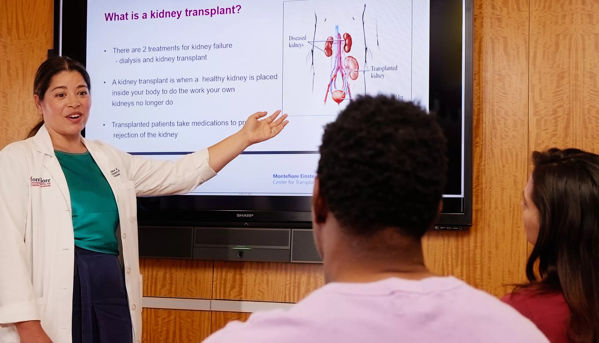 A physician in front of a screen presenting to a patient