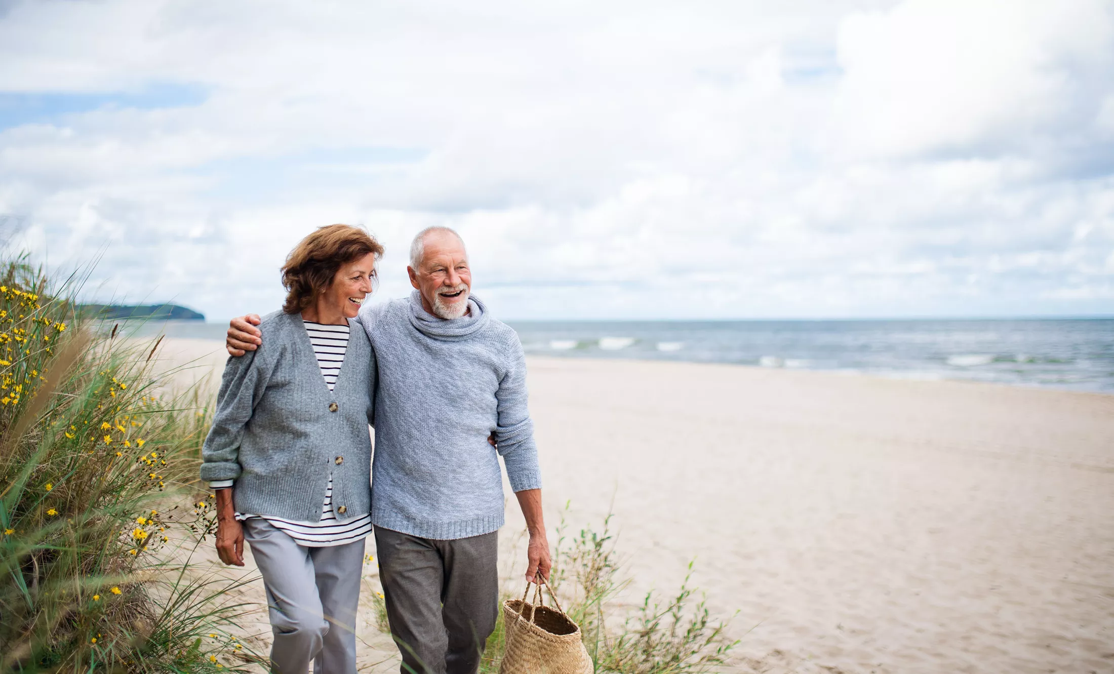 A happy man and woman walking on the beach