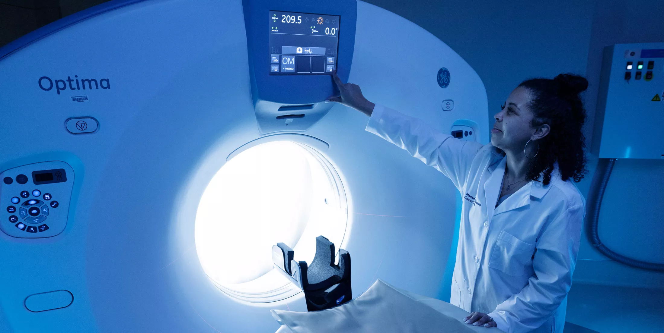 A physician standing by a CT machine