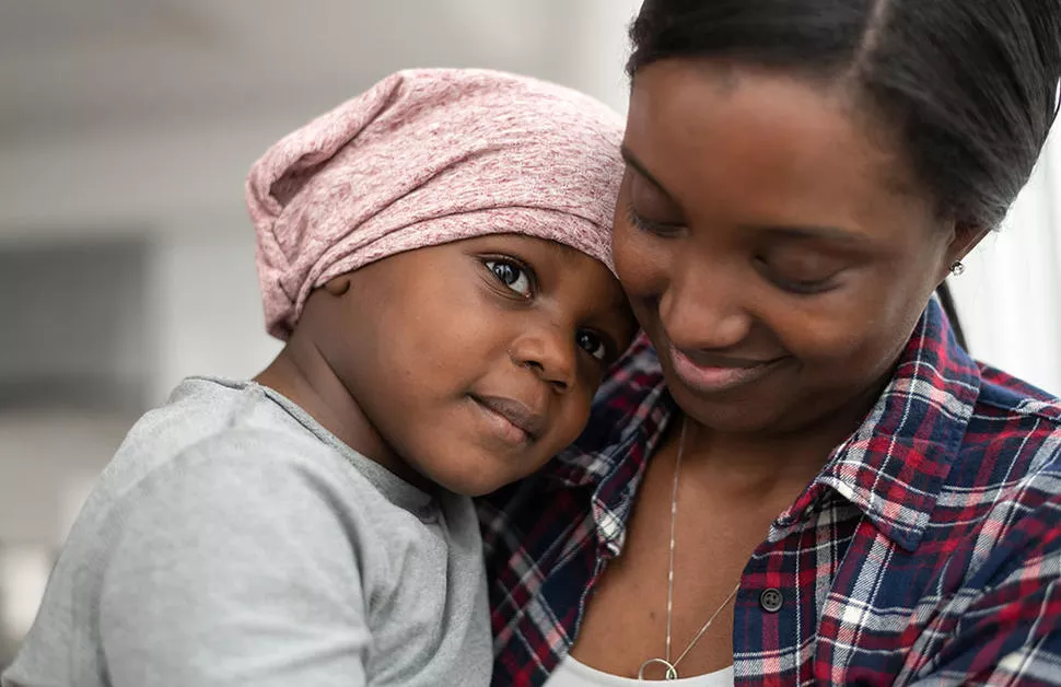 Mother of african descent cuddles her child who has cancer