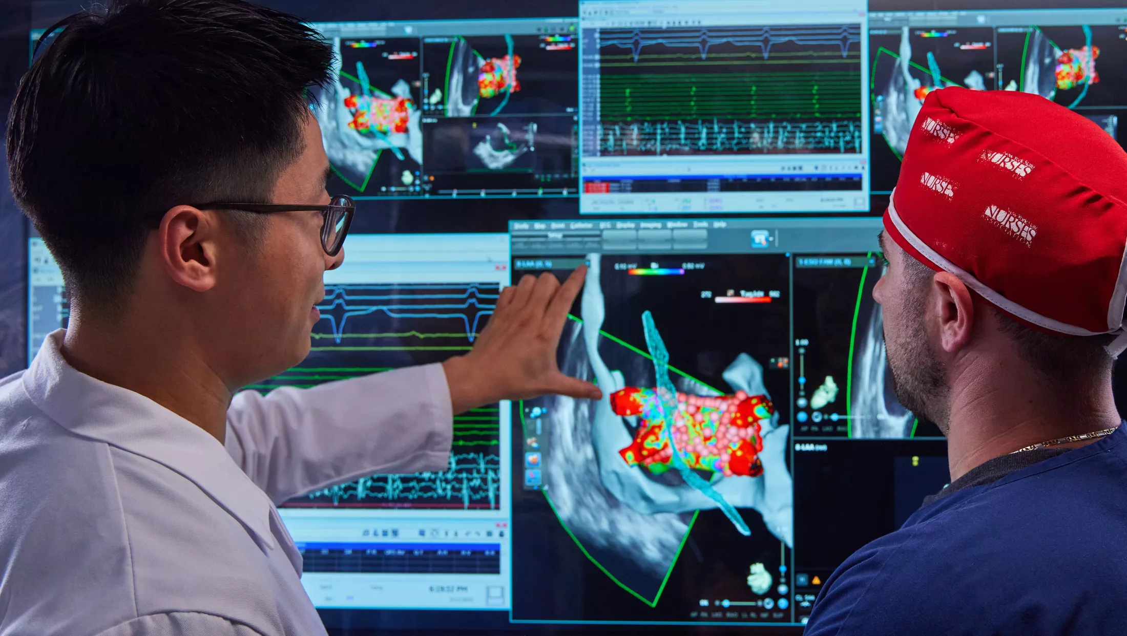 A physician in a lab looking at a screen