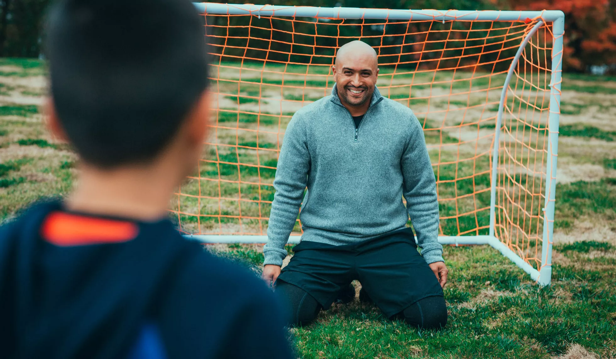 Joseph playing soccer with his son outside
