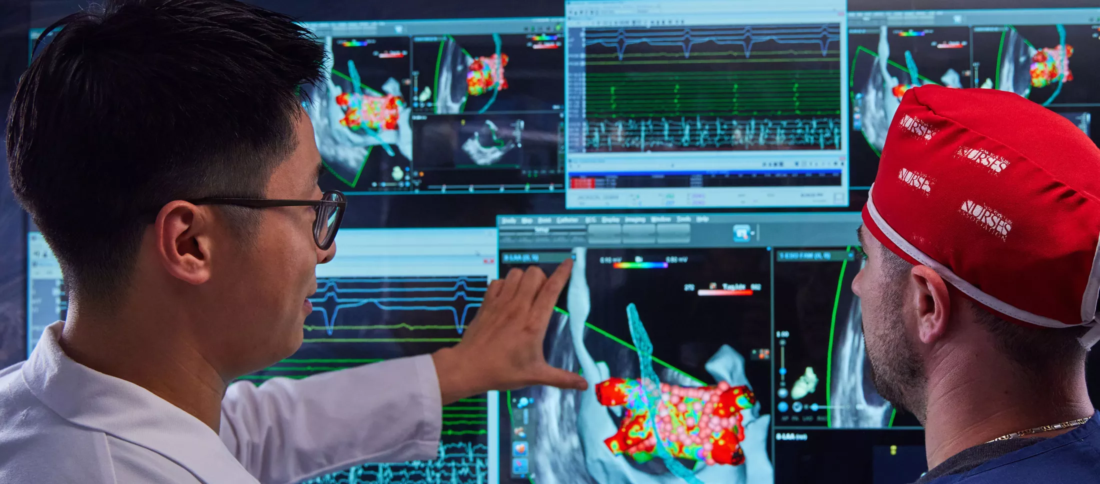 Two physicians in a lab looking at computer screens