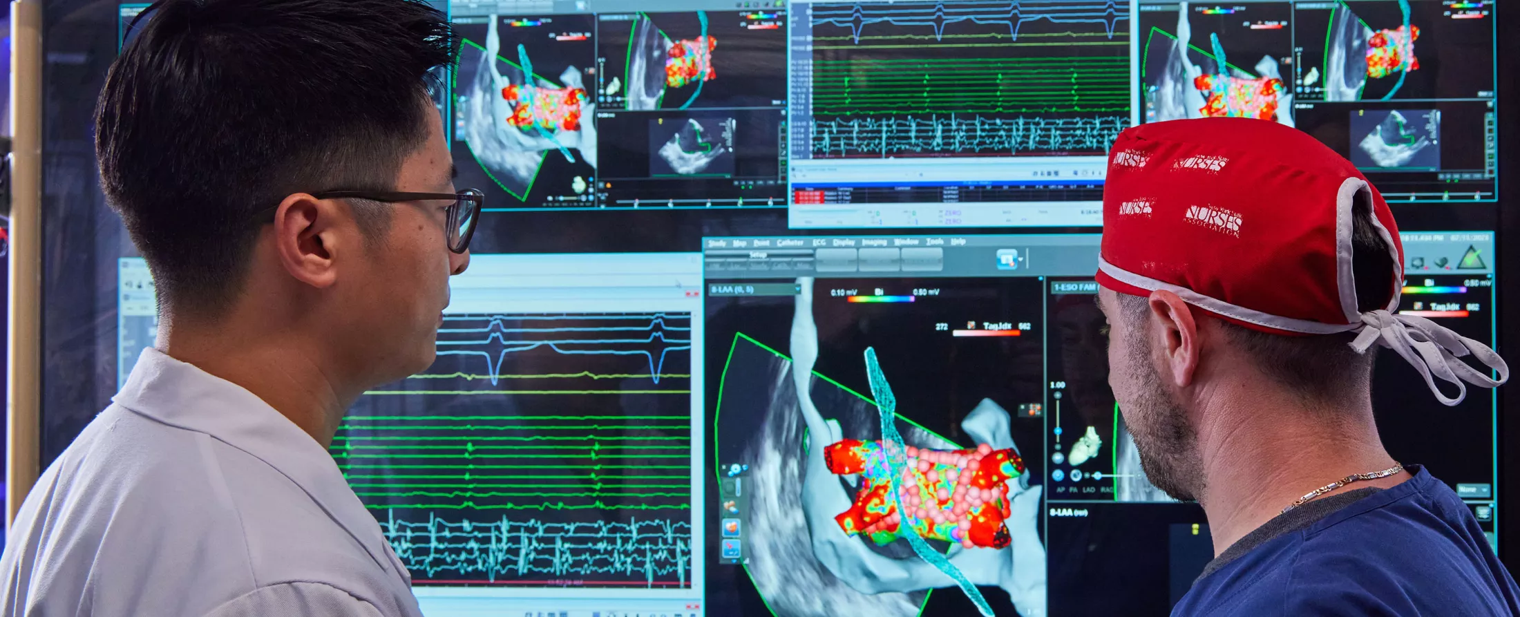 Two doctors in a lab looking at screens