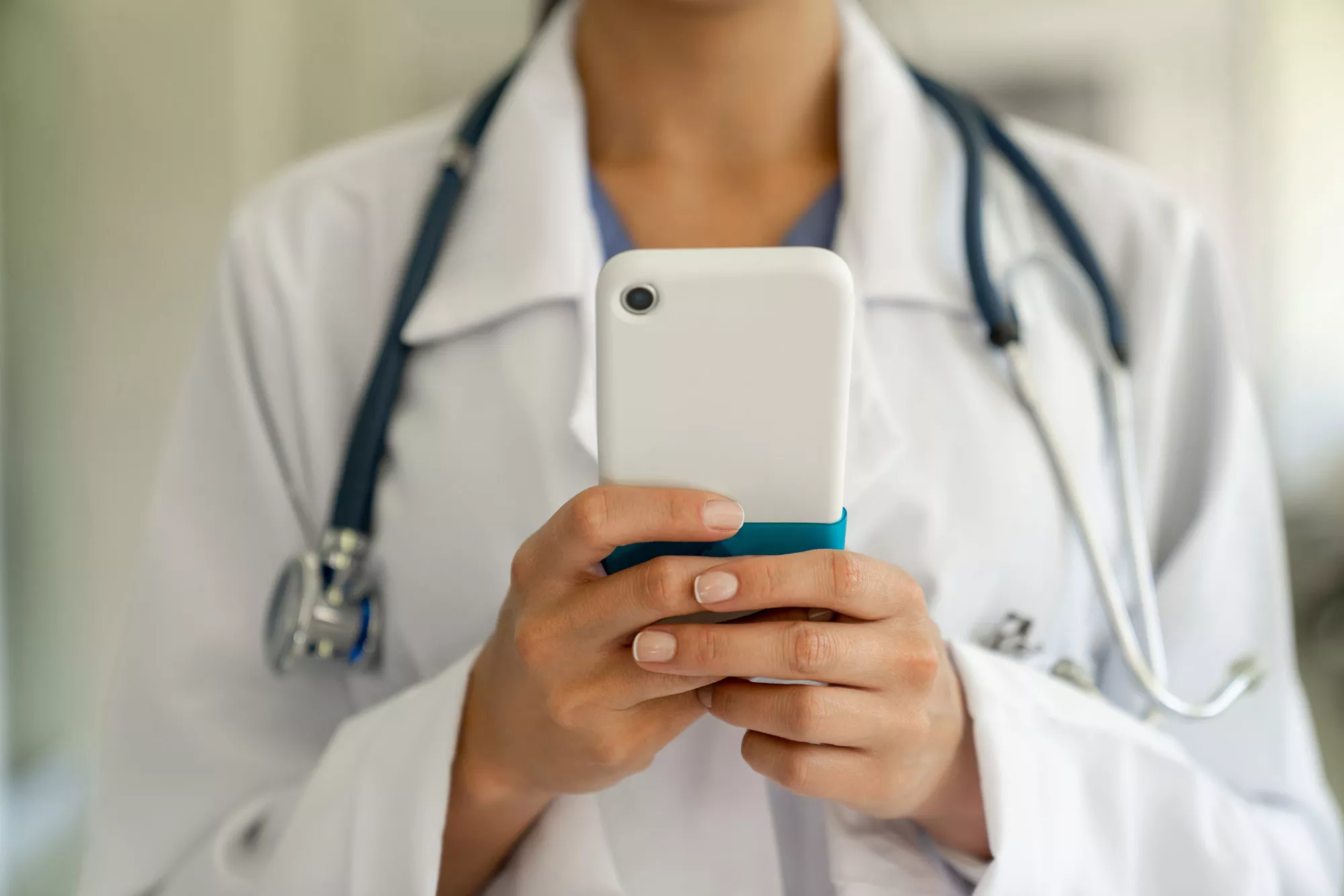 A physician on her phone typing a message