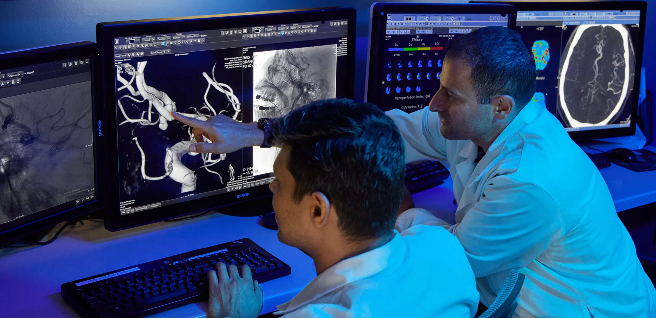Two physicians in a lab looking at computer screens