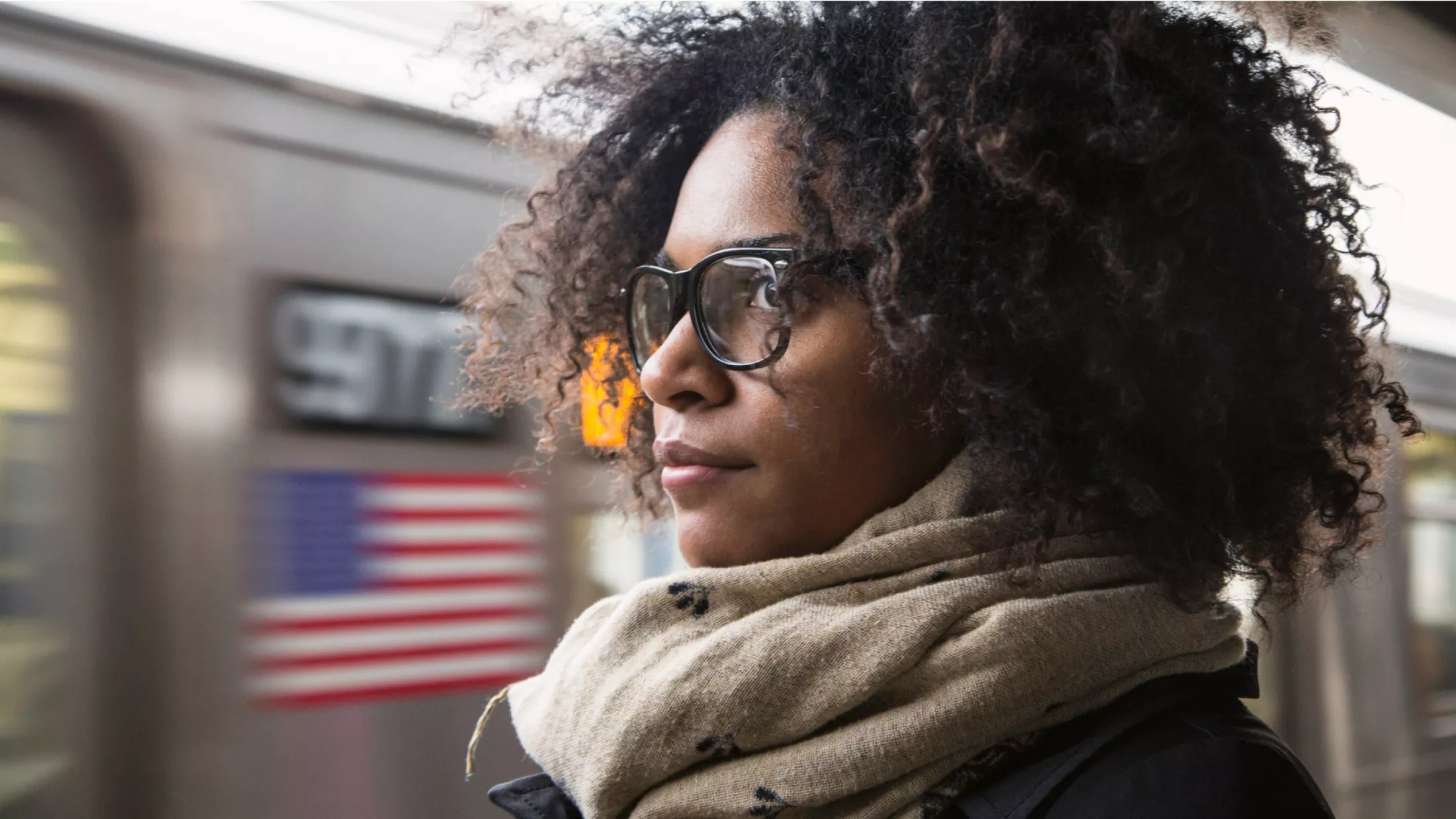 A woman looks into the distance at a subway station.