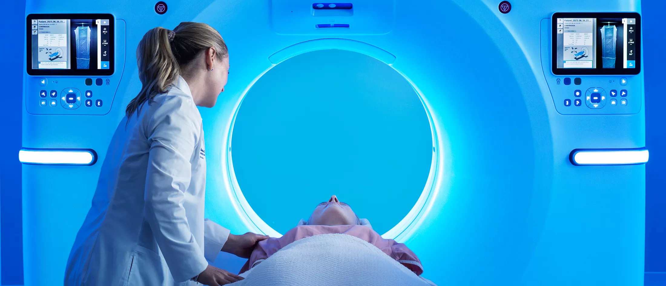 A physician helping a patient go through a MRI macihne