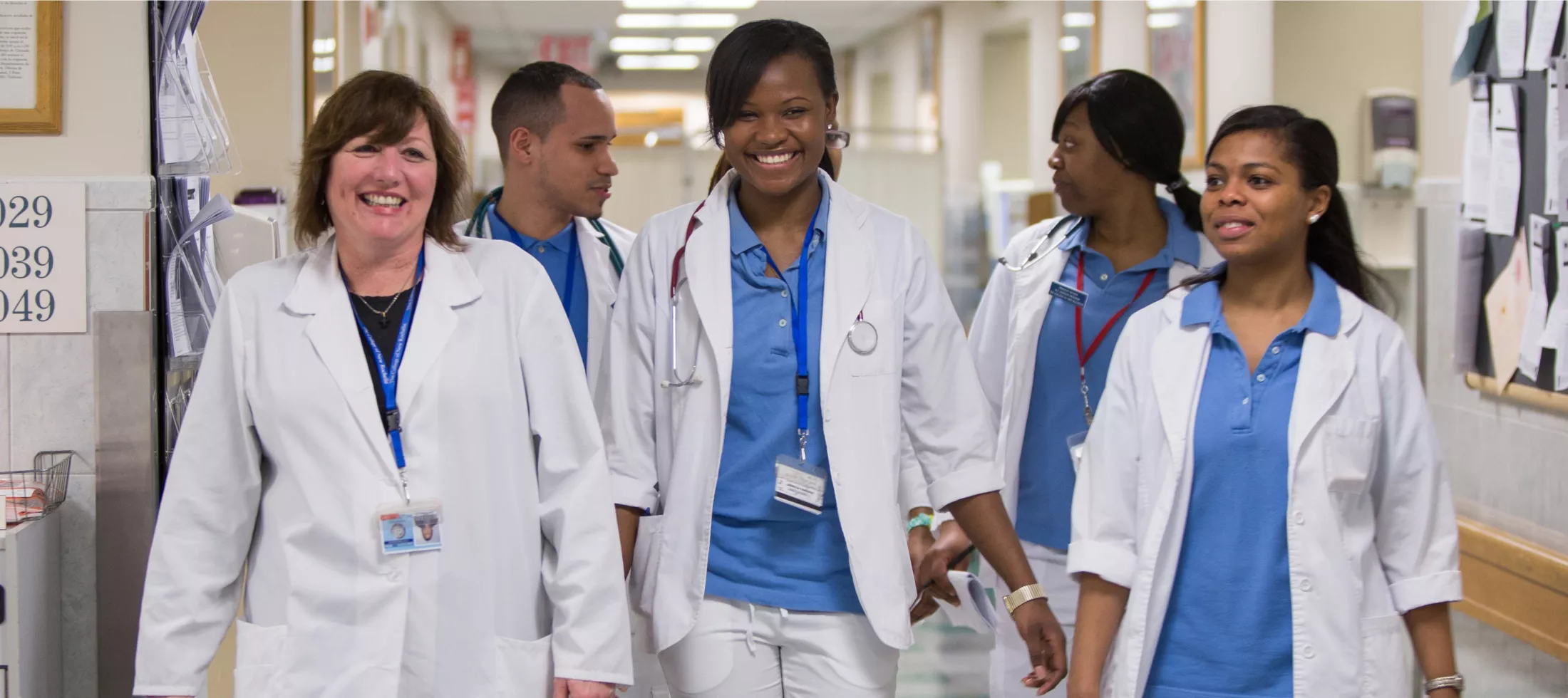 Team of nurses smiling walking down hallway