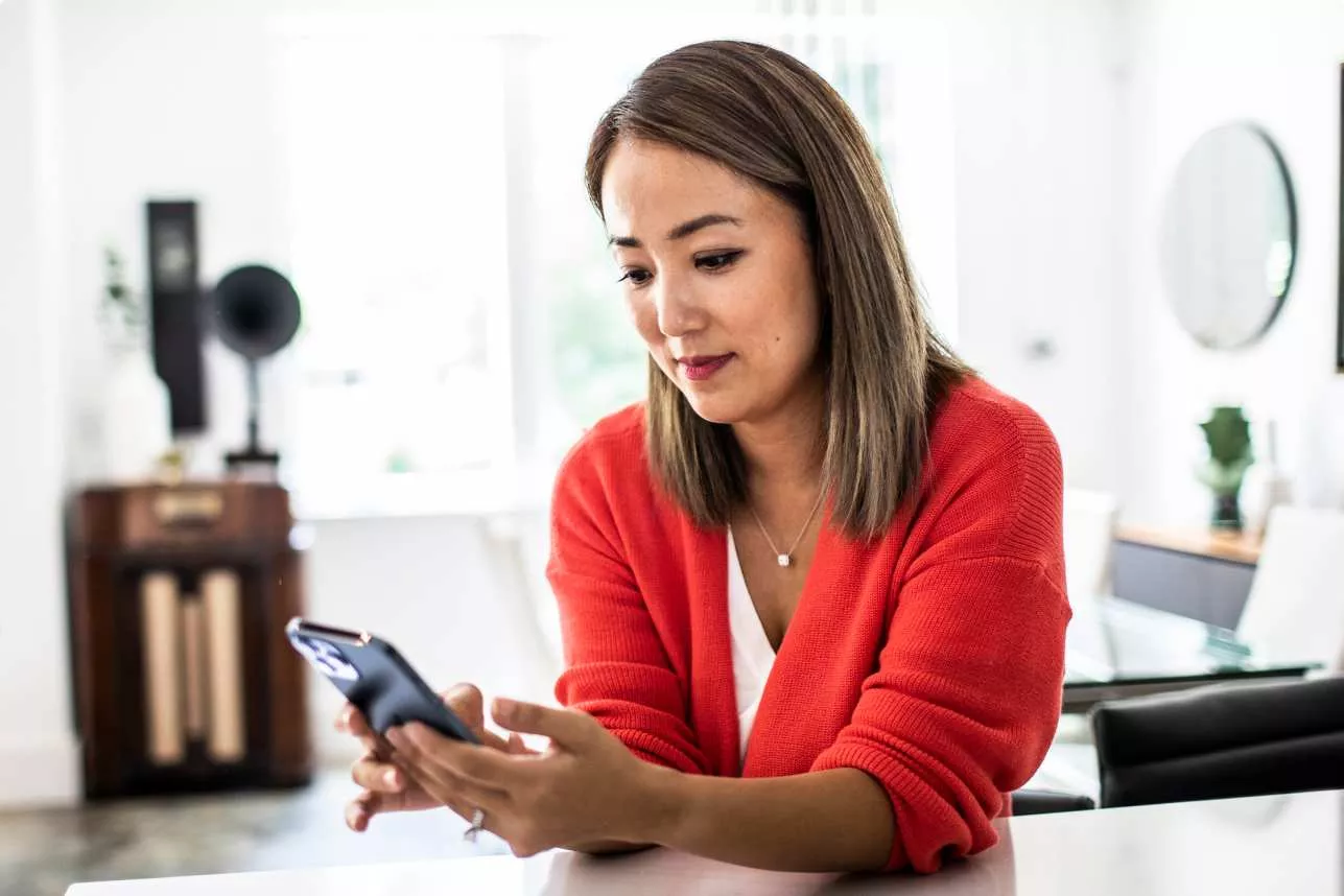Woman sitting at table interacting with her phone