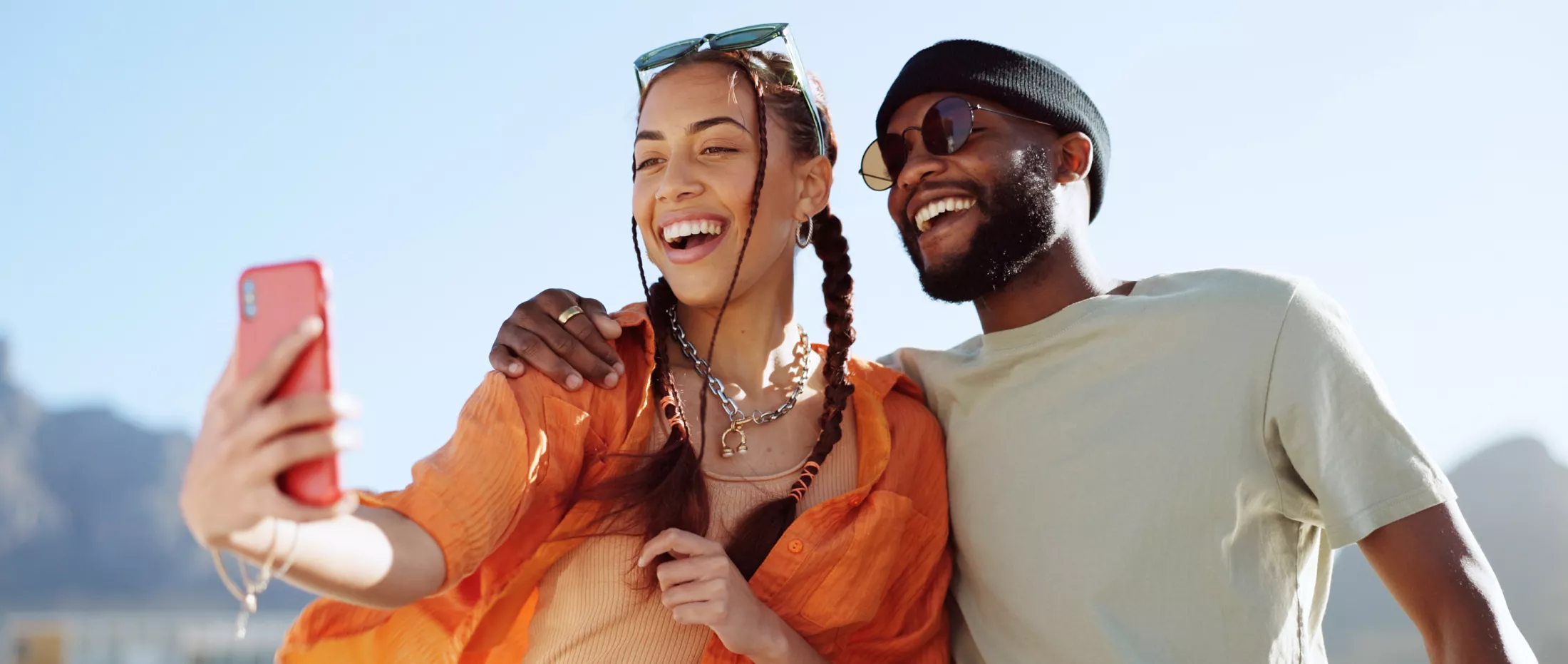 Happy couple taking a selfie outdoors on a sunny day