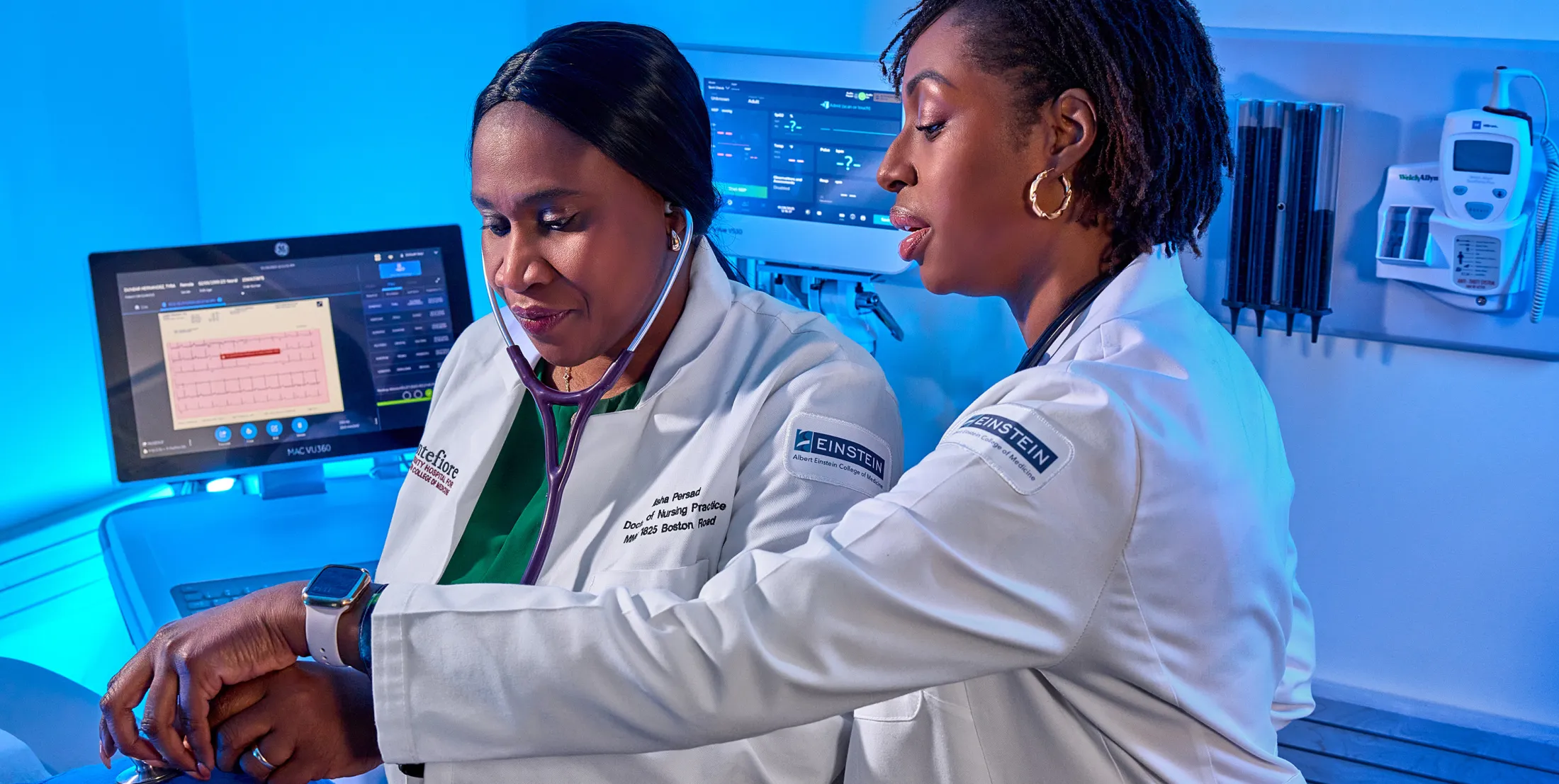 Two medical professionals in lab coats collaborate while using medical equipment in a high-tech clinical setting.