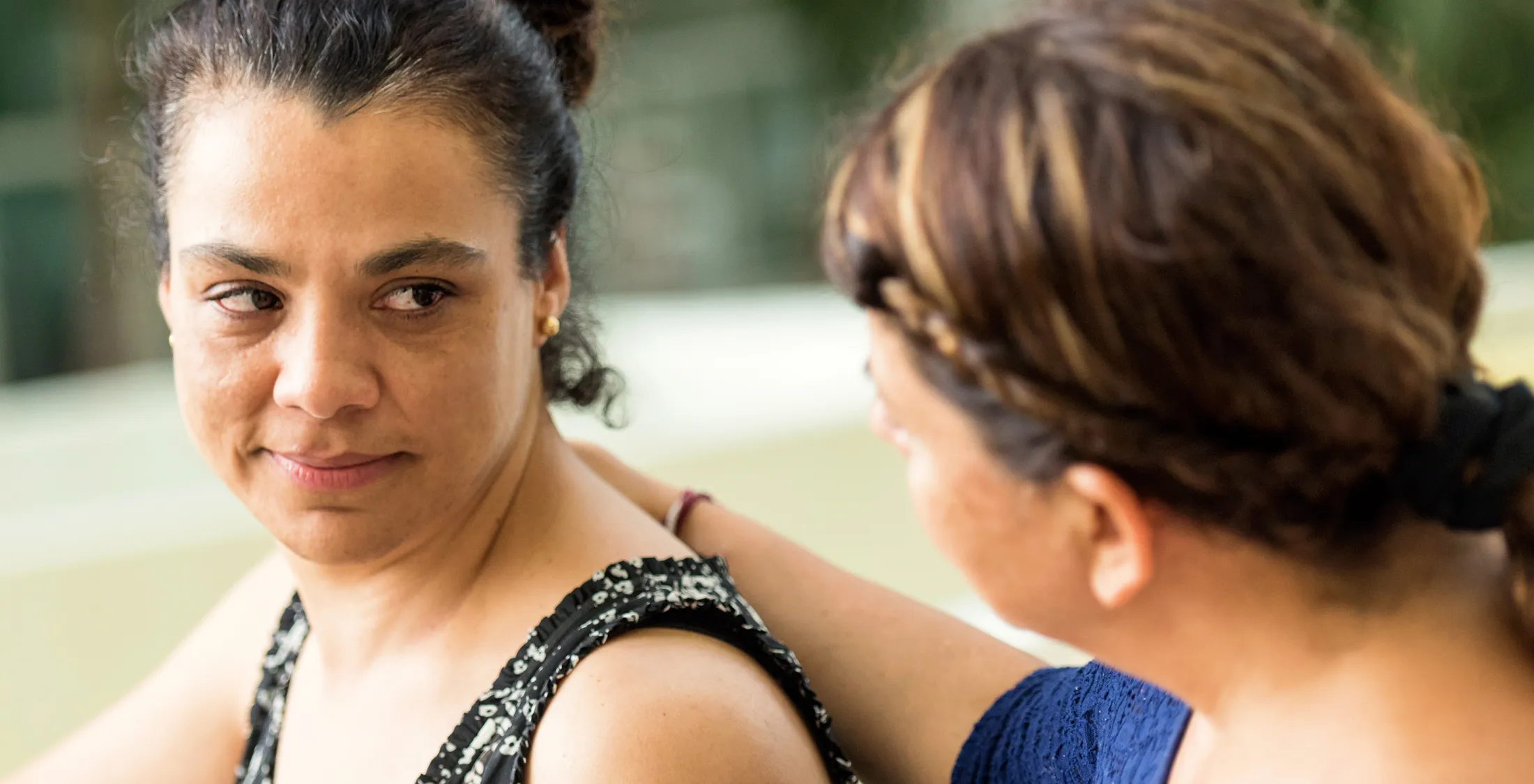 Concerned woman being comforted by a friend with a hand on her shoulder