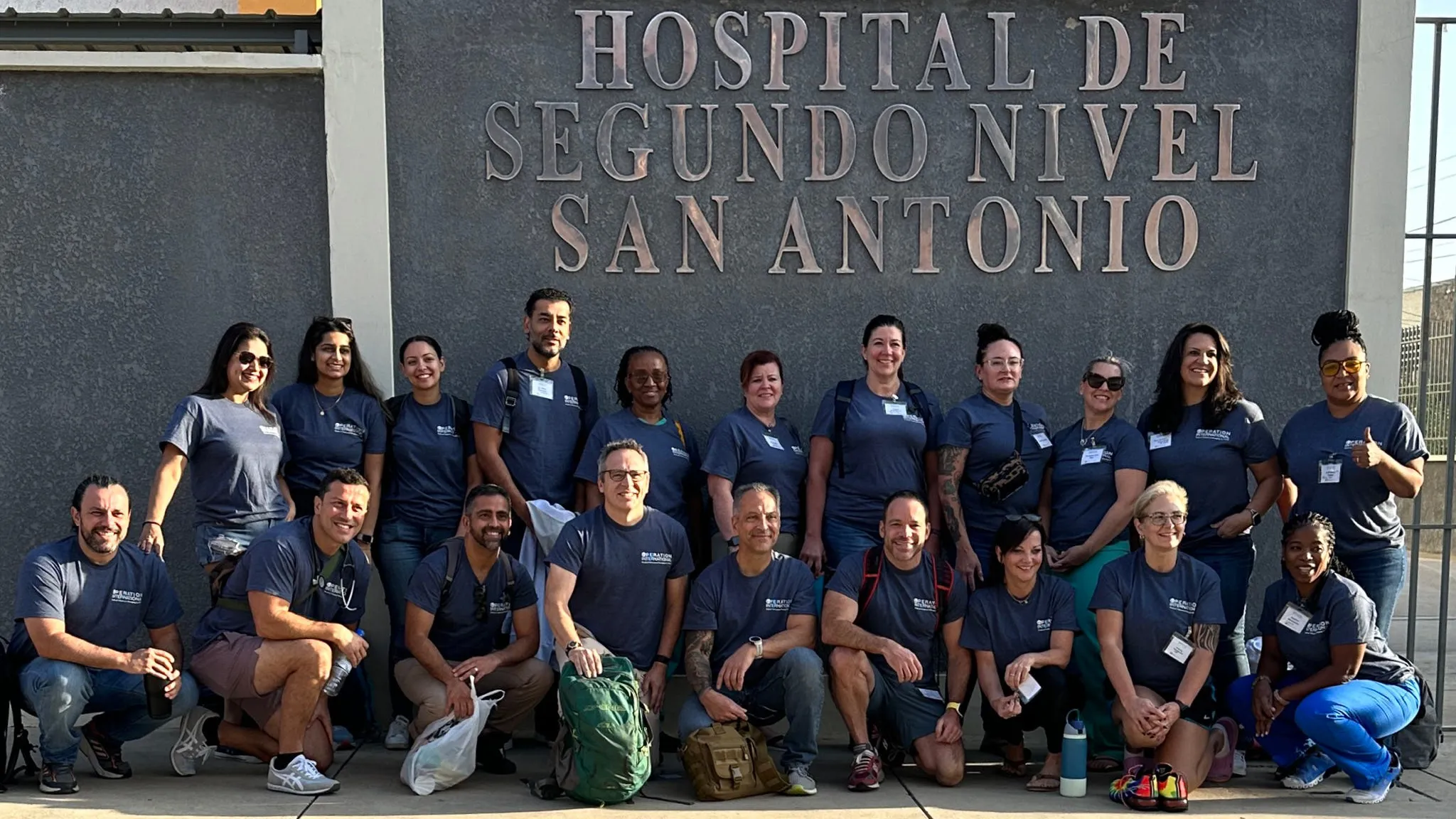 Group of volunteers in matching shirts posing outside Hospital de Segundo Nivel San Antonio in Bolivia during a medical mission trip.