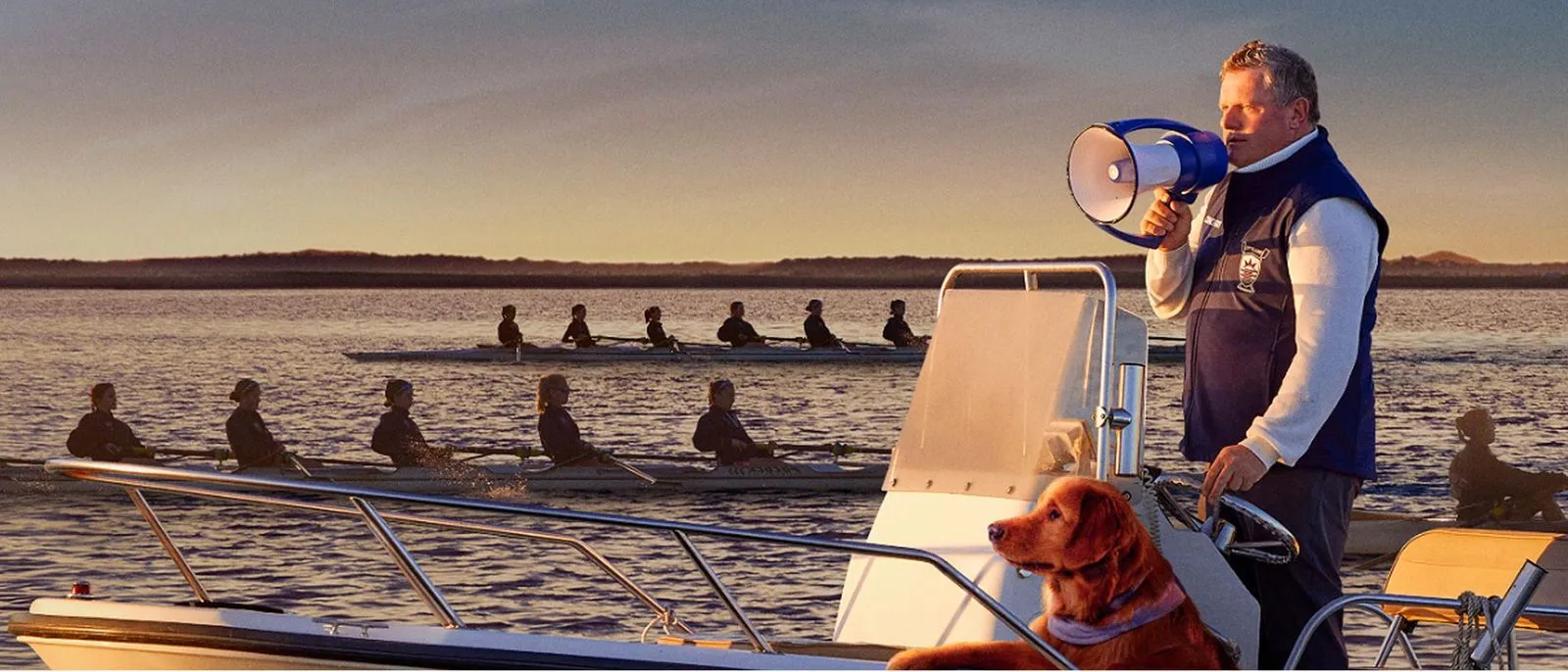Montefiore Einstein patient, Guy Monseair, holding megaphone coaching rowing team on lake with dog