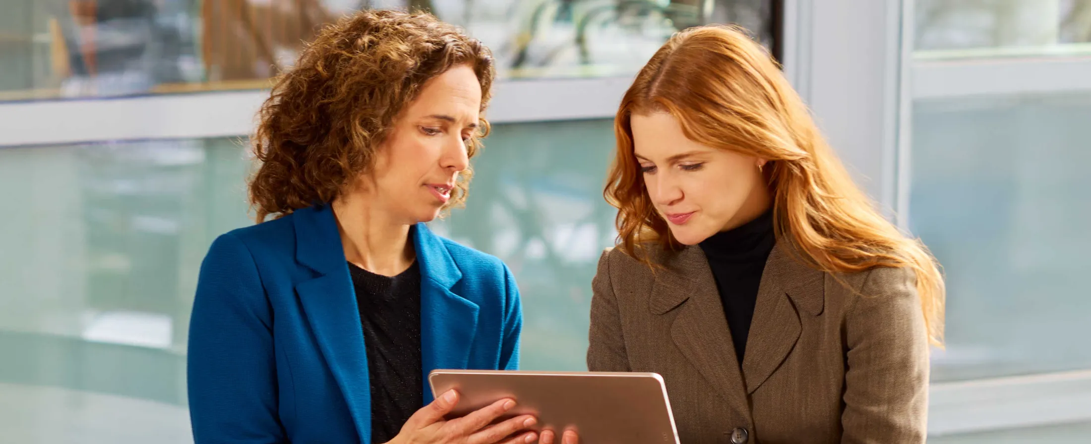 Ladies looking at Tablet screen sitting outside