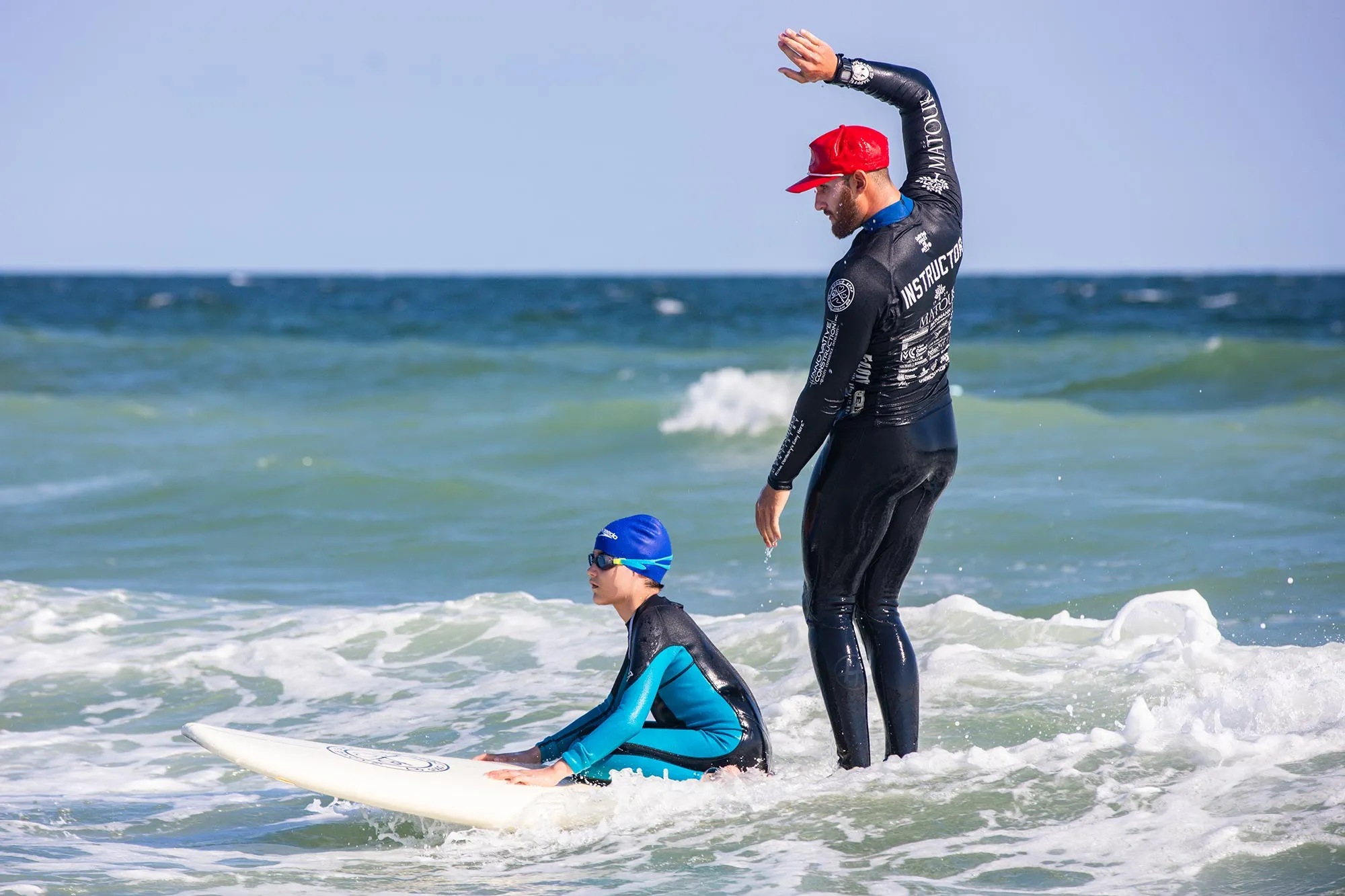 Zachary Trotzky (right), second year M.D. student showing a Gnome Surf participant how to catch a wave