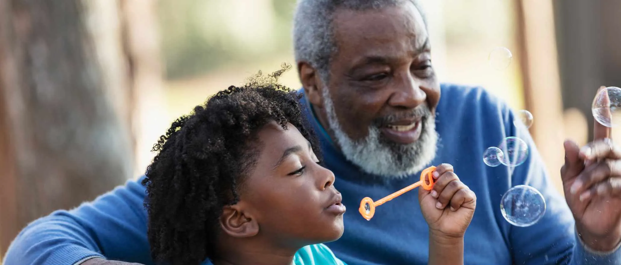 Kid blows bubbles with Grandpa