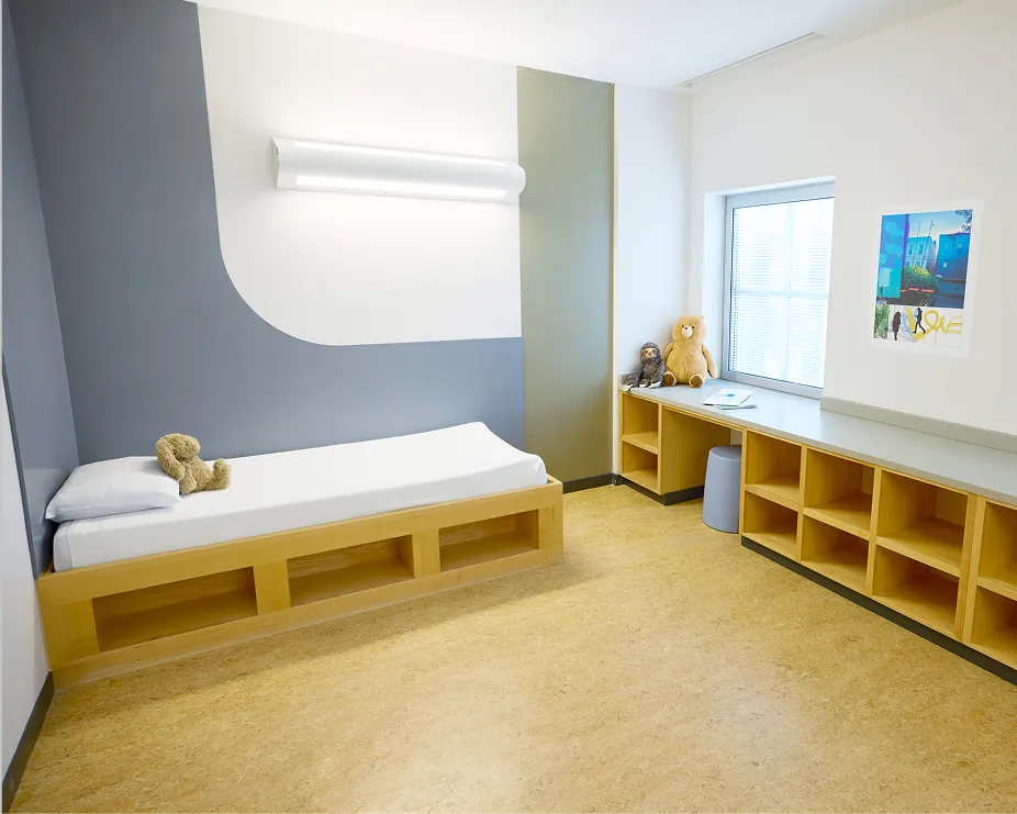 Bed and shelves in a room at the Center