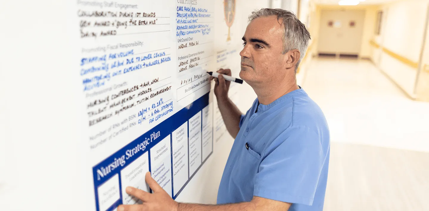 Nurse making notes on wall board