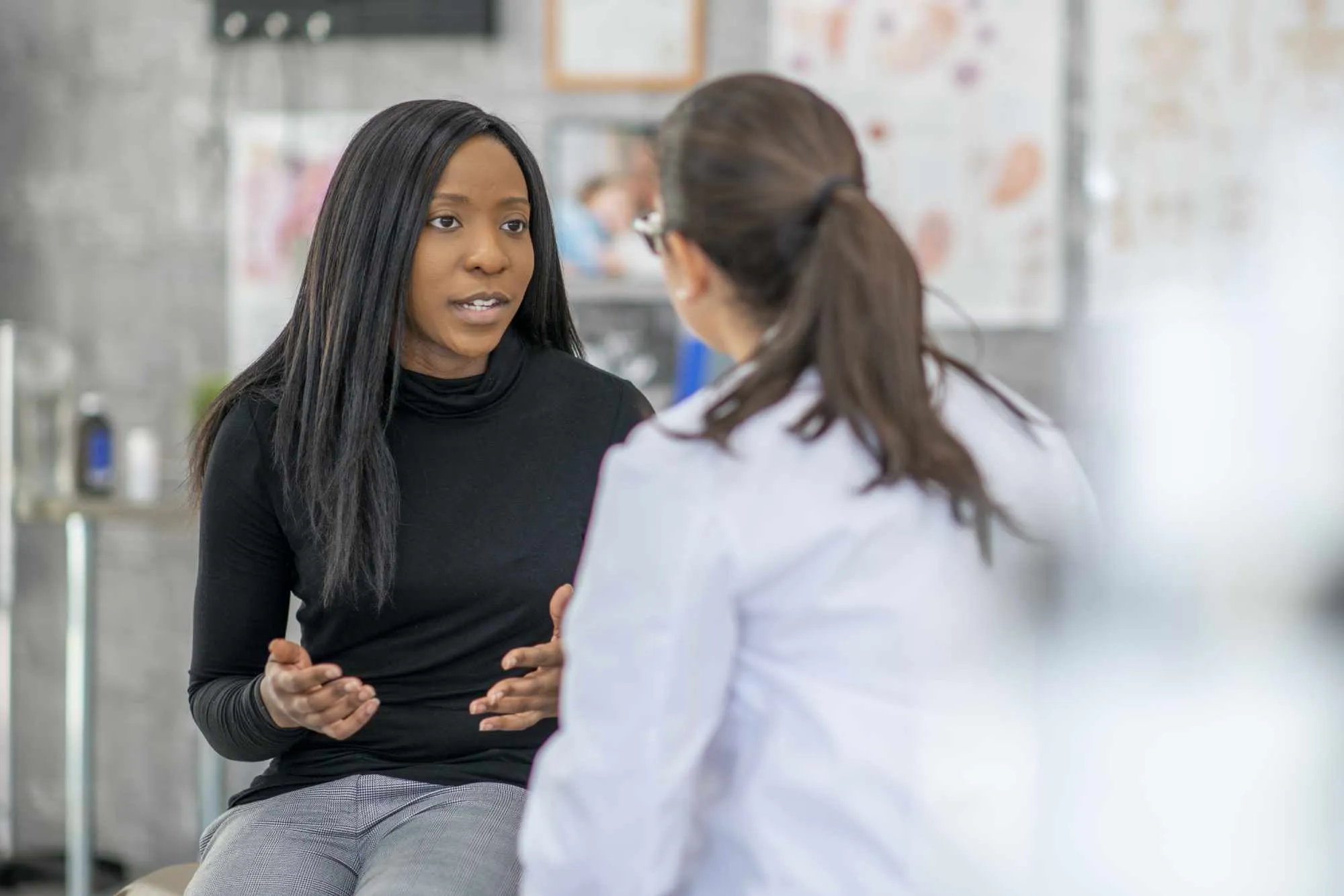 Young woman tallking to female doctor, gesturing with her hands