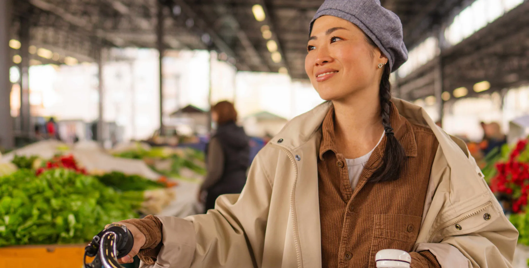 Woman riding a bike at a farmers market smiling