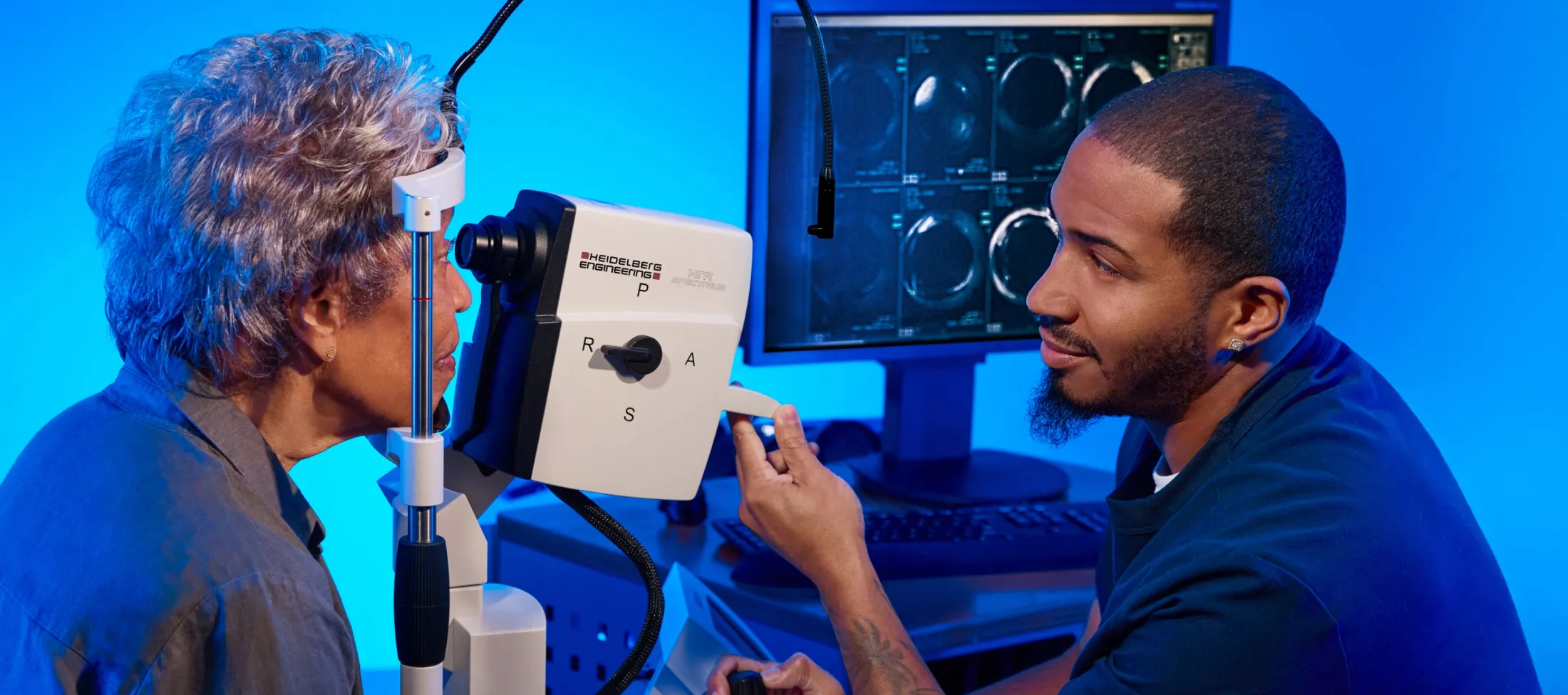 A patient looks into a device during an eye exam