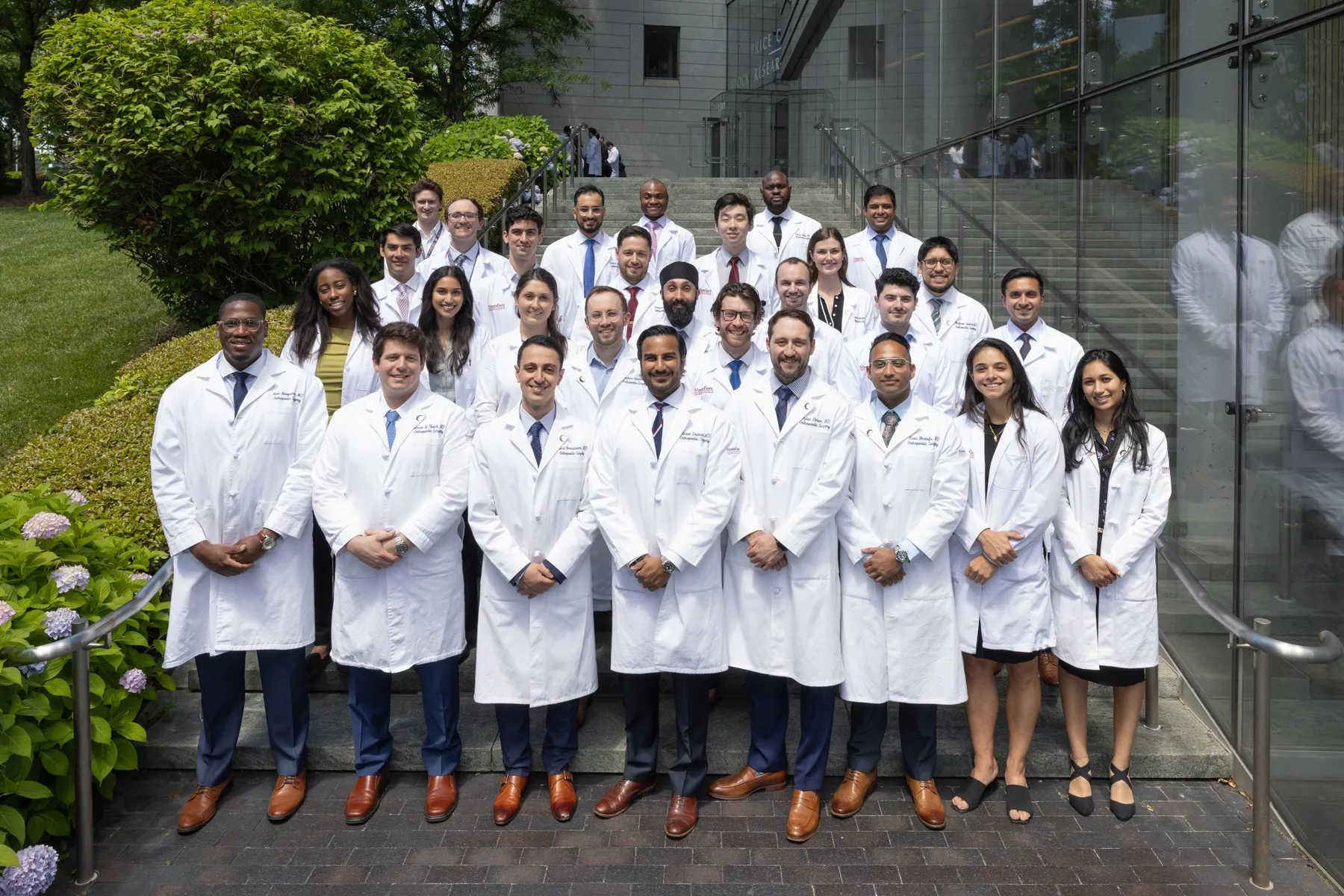 Several doctors wearing white coats pose together, showcasing teamwork and professionalism in a clinical environment