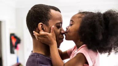 Father enjoying the kiss of his daughter.