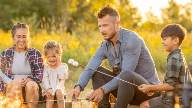 A family enjoying a campfire and roasting smores