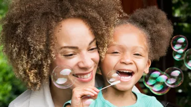Mother and daughter blowing bubbles