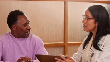 A patient and a transplant coordinator talking at a table