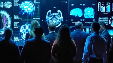 A group of doctors in a lab looking at a video wall