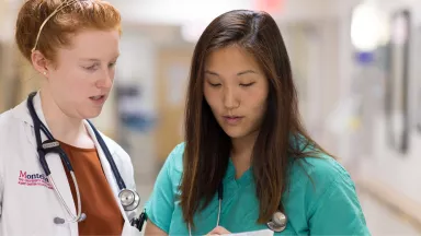 Graduate medical students in hallway reviewing notes
