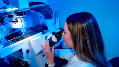 Optical technician looking through a microscope