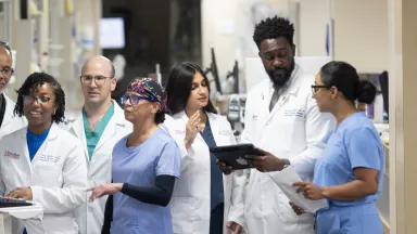 Group of nurses exchanging notes in a hospital corridor