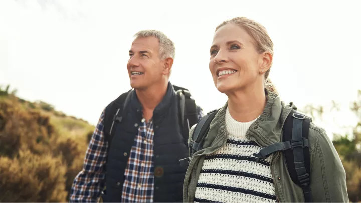 Couple hiking outdoors on a sunny day with backpacks