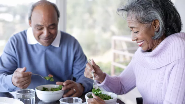 Middle aged woman and man enjoying salads together