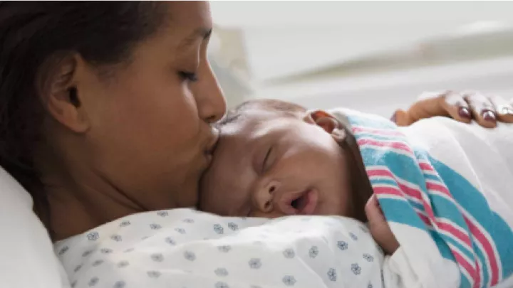 Mother hugging her new born baby and kissing baby