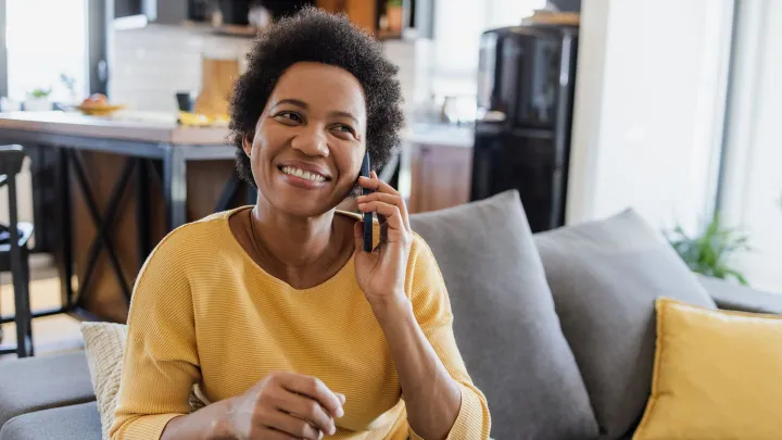 Lady sitting on couch making a phone call
