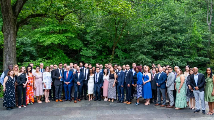Large group portrait of urology department members standing outdoors, dressed in formal and semi-formal attire.