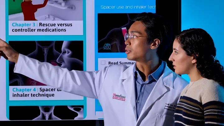 Doctor in a white coat explains inhaler technique diagrams to a patient on a large screen