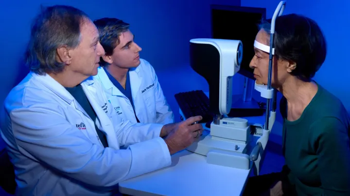 Two ophthalmologists giving an eye exam