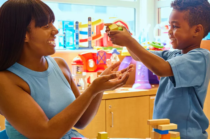A mother and her son playing with toys