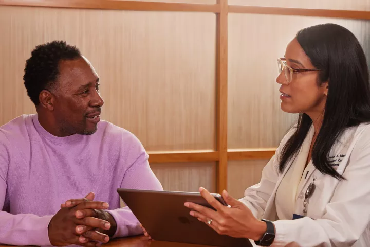 A patient and a transplant coordinator talking at a table