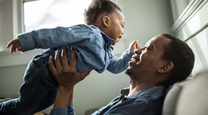Father holding toddler daughter